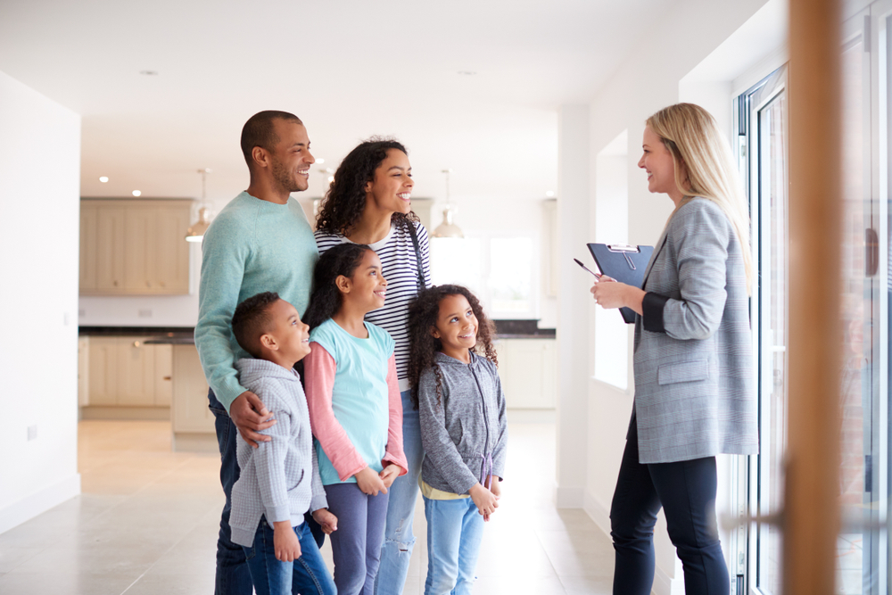 A family speaking with a female agent in a new home